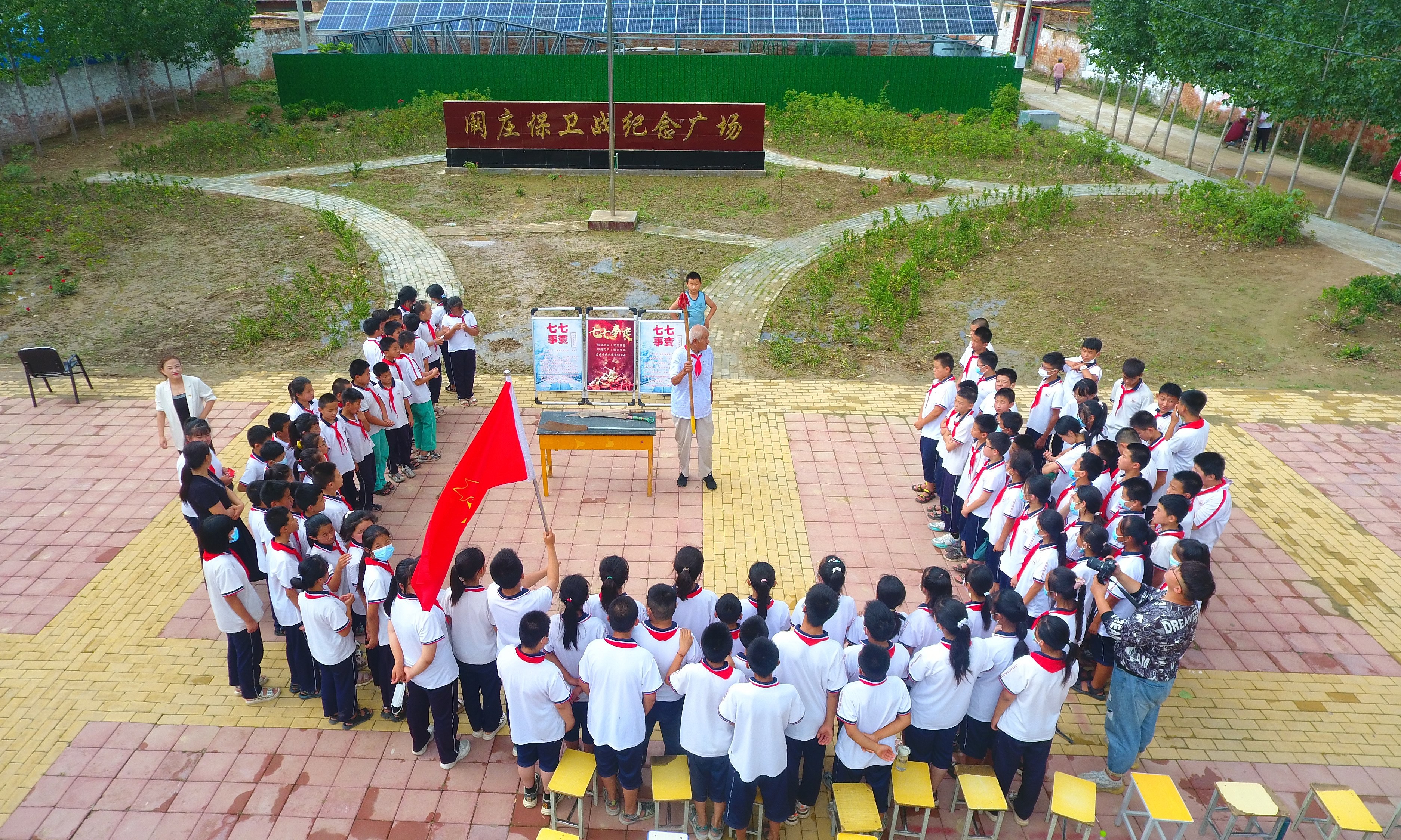 2022年7月6日，山東省聊城市，在茌平區(qū)菜屯鎮(zhèn)闞莊村的闞莊保衛(wèi)戰(zhàn)紀(jì)念廣場，闞莊保衛(wèi)戰(zhàn)親歷者王光木老人，為小學(xué)生們講述抗戰(zhàn)故事，展示大刀、長矛。